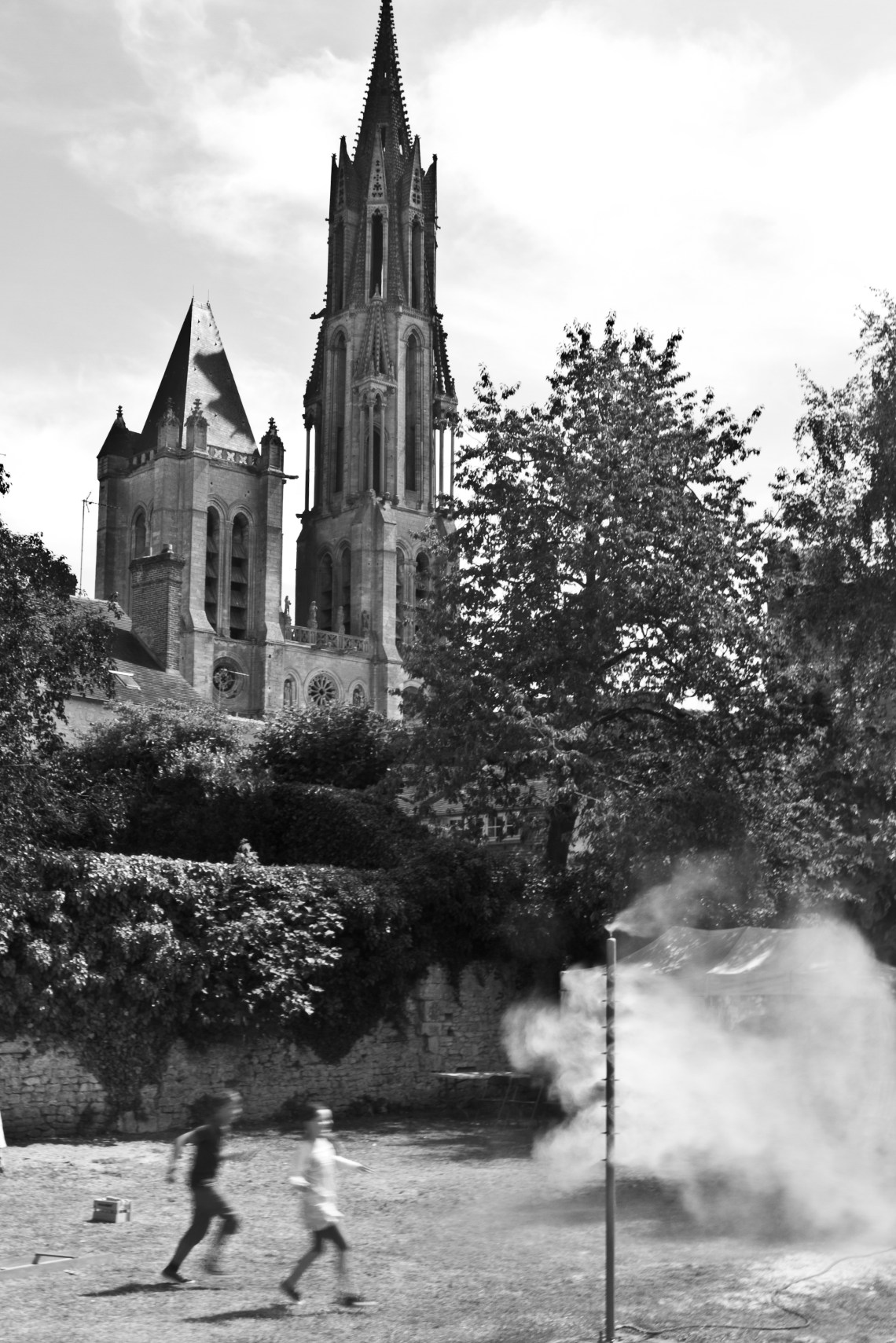 Enfants jouant sous un brumatiseur devant la cathédrale Notre-Dame de Senlis. Photo André Lange-Médart